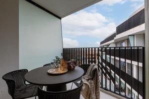 a balcony with a table and chairs on a balcony at Modern apartment close to the beach with common pool in Ostend