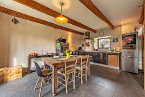 a kitchen with a large wooden table and chairs at Charme et Hâvre de Paix - Grand jardin in Trégarvan