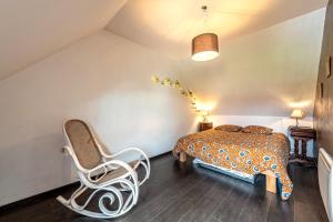 a bedroom with a bed and a chair in it at Charme et Hâvre de Paix - Grand jardin in Trégarvan