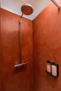 a bathroom with a brown wall with two candles on a shelf at WAY SWEET DREAMS - Room 3 in Ghent