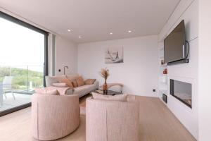 ein Wohnzimmer mit einem Sofa und einem TV in der Unterkunft Luxurious penthouse with beautiful sea view and private parking in De Haan