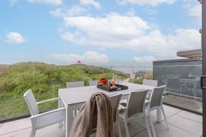 einen weißen Tisch und Stühle auf einem Balkon mit Aussicht in der Unterkunft Luxurious penthouse with beautiful sea view and private parking in De Haan