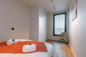 um quarto com uma cama com duas toalhas e uma cadeira em Luxurious penthouse with beautiful sea view and private parking em De Haan
