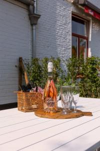 uma garrafa e dois copos de vinho numa mesa em Tosca - Charming double room at ranch "De Blauwe Zaal" em Bruges