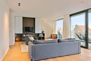 ein Wohnzimmer mit einem Sofa und einem TV in der Unterkunft Majestic new penthouse with 2 parkings in Knokke-Heist