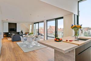 eine Küche und ein Wohnzimmer mit einem Tisch und Stühlen in der Unterkunft Majestic new penthouse with 2 parkings in Knokke-Heist