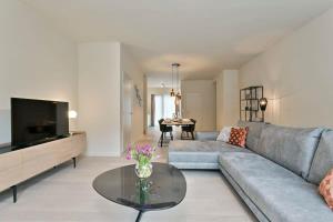 a living room with a couch and a table at Fabulous house near the sea in the Modern O'Sea building in Ostend