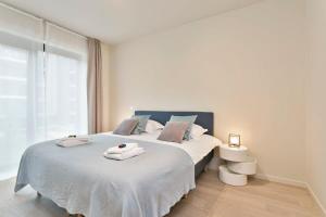 a bedroom with a large bed with towels on it at Fabulous house near the sea in the Modern O'Sea building in Ostend