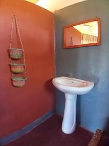 a bathroom with a white sink and a mirror at Ecolodge d'Isalo in Ranohira