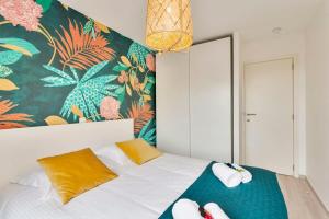 a bedroom with a bed with a colorful wall at Cosy apartment with amazing beach view in Ostend