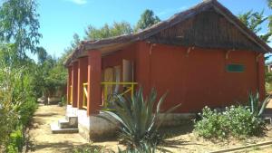 ein kleines rotes Haus mit einem Strohdach in der Unterkunft Ecolodge d'Isalo in Ranohira