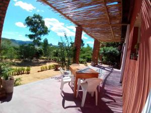 eine Terrasse mit einem Tisch und Stühlen auf einer Veranda in der Unterkunft Ecolodge d'Isalo in Ranohira