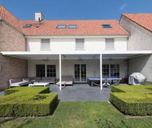 Casa con patio con mesa y bancos en Delicious house for 8 persons with sunny-garden in Duinbergen, en Knokke-Heist