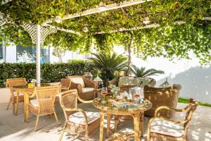 patio con tavoli e sedie sotto un pergolato di Relais Valle Dell'Idro a Otranto