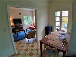 Castello House في باترا: غرفة معيشة مع طاولة خشبية وغرفة طعام