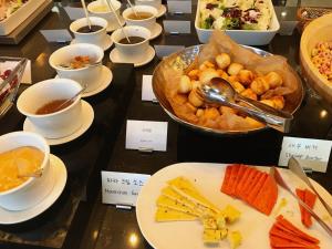 una mesa cubierta con platos de comida y tazones de comida en Mercure Ambassador Seoul Hongdae en Seúl