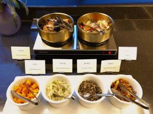 a buffet with bowls of different types of food at Mercure Ambassador Seoul Hongdae in Seoul