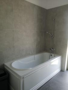 a white bath tub in a bathroom with a wall at AURORA suites in Ghiroda