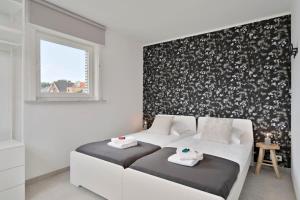 a bedroom with a white couch and a black and white wall at Bright and spacious bungalow with garden near the beach in Middelkerke