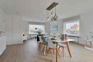 a dining room and kitchen with a table and chairs at Bright and spacious bungalow with garden near the beach in Middelkerke