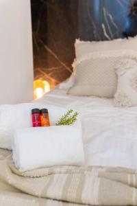 een bed met witte lakens en kussens met drie kaarsen bij Stylish apartment with cosy fireplace near the sea in Knokke-Heist