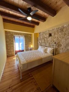 a bedroom with a bed with a ceiling fan at Home · Makrades Corfu in Makrádes