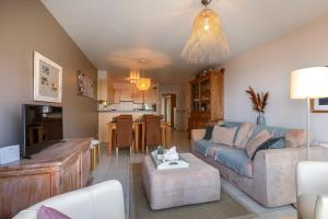 Una sala de estar con un sofá y una cocina. en Huswell - Lovely apartment with lateral sea view, en Middelkerke