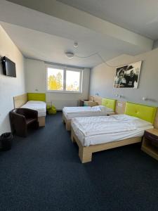 Cette chambre comprend 3 lits et une fenêtre. dans l'établissement Sport hotel Sletiště, à Kladno