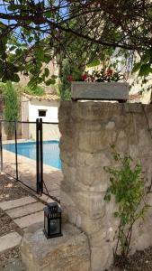 une lumière sur un mur en pierre à côté d'une piscine dans l'établissement Maison Pelissier - Chambres d’hôtes avec piscine, à Cuxac-dʼAude