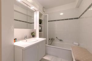 Baño blanco con lavabo y bañera en Huswell - Lovely apartment with lateral sea view, en Middelkerke 14 fotos más
