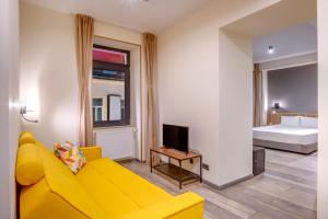 a living room with a yellow couch and a bed at Hotel Forty One in Bucharest