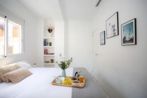 バレンシアにあるSingularStays Roger de Florの白い部屋(ベッドの上にフルーツのトレイ付)
