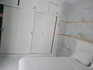 een witte badkamer met een spiegel en een raam bij super appartment in tetouan in Martil