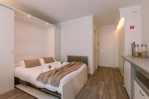 1 dormitorio con 1 cama blanca grande en la cocina en Warm studio with sea view and view on the new casino, en Middelkerke