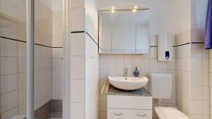 a white bathroom with a sink and a toilet at Ferienhaus Möwe in Lancken-Granitz