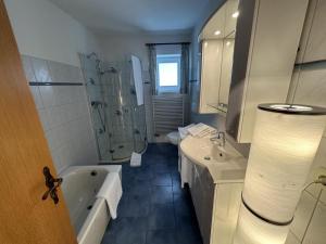 a bathroom with a tub and a sink and a shower at Fehmarn 17-7 in Fehmarn +11 photos