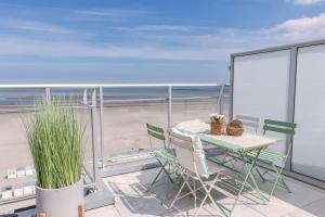 克诺克－海斯特Huswell - Stunning Seafront Apartment的海滩阳台的桌椅