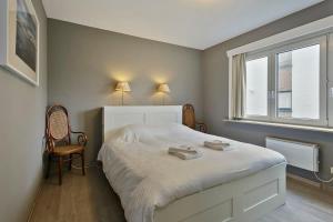 een slaapkamer met een bed en een raam bij Lovely Family Apartment 50 meters from the Sea in De Haan