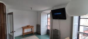 Una habitación con un televisor de pantalla plana en una pared. en PISO CON TERRAZA, en Ribadeo
