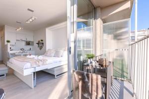 Un dormitorio con una cama y un balcón. en Huswell - Modern studio near the sea and beach, en Nieuwpoort