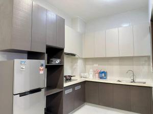  La cuisine est équipée de placards blancs et d'un réfrigérateur. dans l'établissement OceanVista Oasis: Seaview Haven 2 Bedroom【Netflix】, à Johor Bahru
