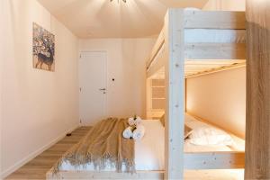 een kleine slaapkamer met een stapelbed en een ladder bij Bright apartment only 5 minutes from the beach in Middelkerke