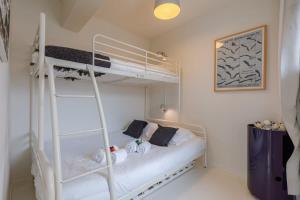 a bedroom with a bunk bed with a ladder at Pleasant Apartment for Families close to the beach in De Haan