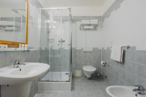 a bathroom with a sink and a shower and a toilet at Louis Leger in Prague