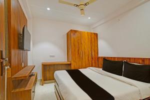 OYO Hotel Delight Stay في إندوري: غرفة نوم فيها سرير وتلفزيون