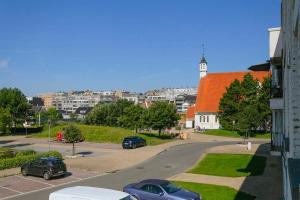 a city street with cars parked in a parking lot at Huswell - Sea Bridge; Charming apartment near the beach in Bruges