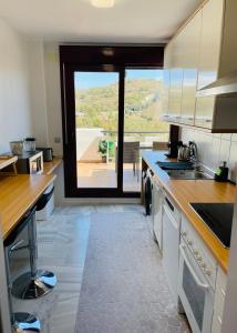 a kitchen with a large view of a balcony at Parque Botanico Benahavis in Estepona