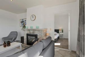 a living room with a couch and a fireplace at Huswell - Sea Bridge; Charming apartment near the beach in Bruges
