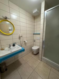 a bathroom with a sink and a toilet and a mirror at Sport hotel Sletiště in Kladno