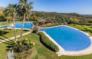 uma vista sobre uma grande piscina com palmeiras em Parque Botanico Benahavis em Estepona